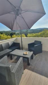 een patio met een tafel en stoelen en een parasol bij Macrisbete 2 in Fátima