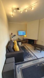 a living room with a couch and a flat screen tv at Macrisbete 2 in Fátima