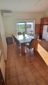 a dining room with a table and chairs and a kitchen at Macrisbete 2 in Fátima