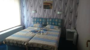 1 dormitorio con 1 cama con manta azul y blanca en Enjoy Guest House, en Golden Sands