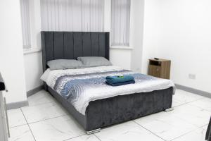 Una cama en una habitación blanca con una bolsa azul. en Hills View Apartments en Mánchester