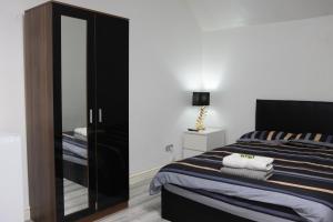 a bedroom with a large bed and a mirror at Hills View Apartments in Manchester