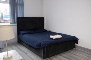 a bedroom with a black bed with a blue mattress at Hills View Apartments in Manchester