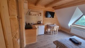 a small kitchen and dining area of a tiny house at Pod Gruszą in Dzianisz