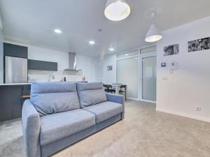sala de estar con sofá azul y cocina en Apartment Sua Loft by Clabao, en Pamplona