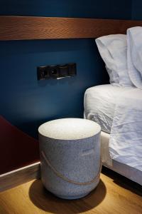 a ottoman sitting in a room next to two beds at K2 Suites Kalamata in Kalamata