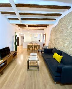 ein Wohnzimmer mit einem blauen Sofa und einem Tisch in der Unterkunft AZ El Balcón de Rey Alfonso I in Saragossa