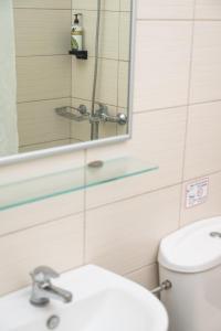 a bathroom with a toilet and a sink and a mirror at Konstantinos Hotel & Apartments 2 in Nydri