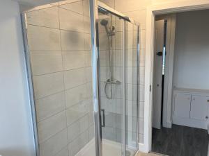 y baño con ducha y puerta de cristal. en King Street Apartments en Southport