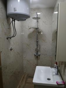 a bathroom with a white sink and a shower at VILLA ORYX free double garage parking in Sarajevo