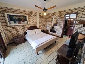 1 dormitorio con 1 cama en una pared de ladrillo en Casa para 10 pessoas a 150m da praia - C130, en Florianópolis