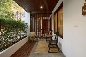 a screened in porch with chairs and a table at Jambolan Chiangmai in Chiang Mai