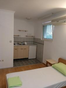 a bedroom with a white bed and a kitchen at Car Konaci in Smederevo