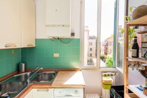 a green and white kitchen with a sink and windows at Appartamento a Montesacro, Città Giardino in Rome