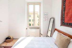 sypialnia z białym łóżkiem i oknem w obiekcie Appartamento a Montesacro, Città Giardino w Rzymie