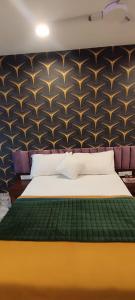 Hotel Shaswat Inn في أحمد آباد: غرفة نوم بسرير وجدار