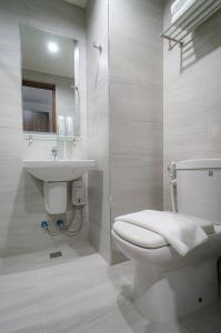 a white bathroom with a toilet and a sink at Mangrove Place and Residences by Hiverooms in Mactan