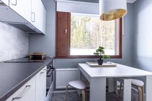 a kitchen with a white table and a window at Holiday Apartment Usva Studio II in Suomutunturi