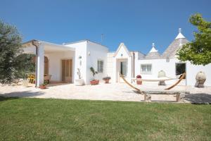 Casa blanca con hamaca en el patio en Trulli Greta, luxury villa with wonderful pool, en Martina Franca