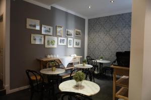 a restaurant with tables and chairs and pictures on the wall at Hotel Pension Lumes - Self Check In in Vienna