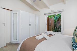 um quarto com uma cama com paredes brancas e uma janela em San Lameer Villa 2848 - 3 Bedroom Classic - 6 pax - San Lameer Rental Agency em Southbroom