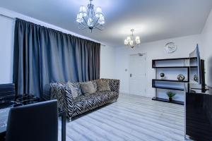 ein Wohnzimmer mit einem Sofa und einem TV in der Unterkunft CrossVille Homes - Double rooms in Navestock