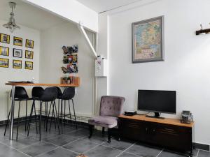 um quarto com uma mesa com cadeiras e uma televisão em LA PETITE MAISON em Beauvais