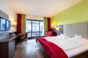 GroßheirathにあるLandhotel Steinerの大きなベッドとデスクが備わるホテルルームです。