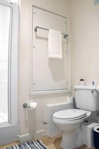 a white bathroom with a toilet and a window at Bright 2Bed Central Apartment in Milton Keynes