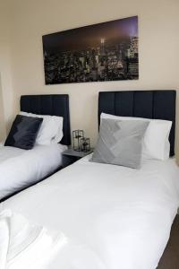 two beds sitting next to each other in a bedroom at Bright 2Bed Central Apartment in Milton Keynes