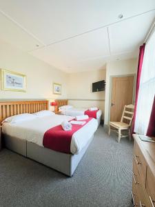 a hotel room with two beds and a flat screen tv at The Western in St Ives
