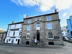 an old stone building on the corner of a street at The Western in St Ives