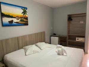 a bedroom with a bed with a teddy bear on it at Hotel Fortaleza Inn in Fortaleza