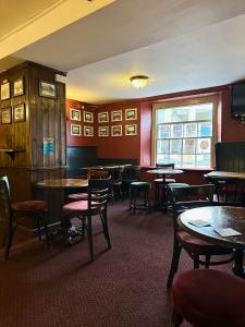 a dining room with tables and chairs and a window at The Western in St Ives