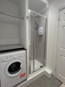 y baño con ducha y lavadora. en New modern studio flat, en Brighton & Hove