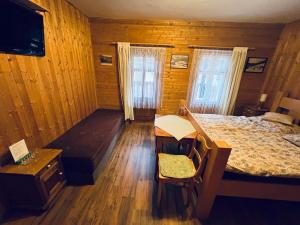 a bedroom with a bed and a bench in a room at Pension Jaruska in Špindlerův Mlýn