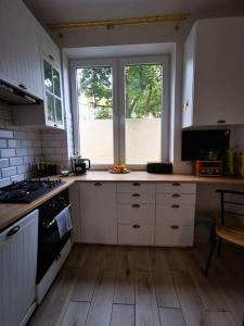 een keuken met witte kasten en een fornuis met oven bij Cosy condo in Warschau