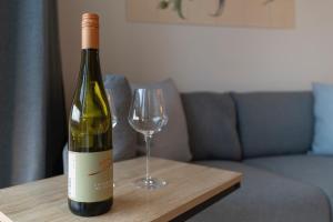 a bottle of wine and a wine glass on a table at Modernes Apartment am Gleispark in Oldenburg