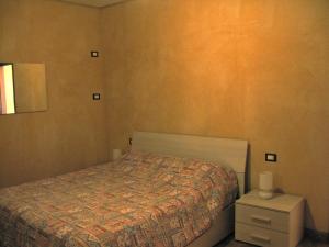 um pequeno quarto com uma cama e uma mesa de cabeceira em Chalet della Rota em Marone