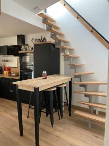 una cocina con una mesa de madera y una escalera en Superbe Appartement atypique, en Bouleternère