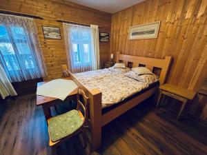 - une chambre avec un lit, une table et une chaise dans l'établissement Pension Jaruska, à Špindlerův Mlýn