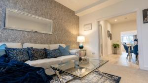 uma sala de estar com um sofá e uma mesa de vidro em Luxury living away from home em Earlswood