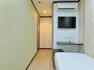 um quarto de hotel com uma cama e uma televisão em One Enigma Hotel em Kuala Lumpur