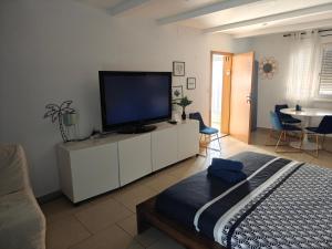 サン・ルイにあるSuite 2 lits Auberge du Manala Hôtel 24 24 proche Baselの白いキャビネット(薄型テレビ付)が備わるベッドルーム1室です。