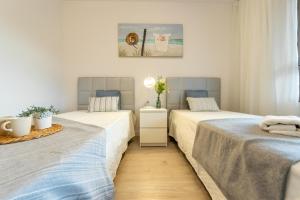 ラ・ピネーダにあるHomes & Go Los Olivosのベッド2台とテーブルのある寝室 +28枚の写真