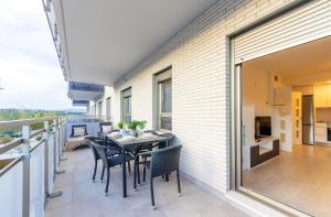 ラ・ピネーダにあるHomes & Go Los Olivosのバルコニーにテーブルと椅子が置かれたパティオ