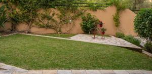 a garden with grass and a stone patio at Konstantinos Hotel & Apartments 2 in Nydri