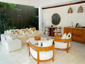 ein Wohnzimmer mit einem Sofa, einem Tisch und Stühlen in der Unterkunft Cocana Resort Gili Trawangan in Gili Trawangan