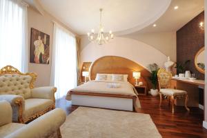 1 dormitorio con 1 cama, 1 silla y 1 lámpara de araña en Silver & Gold Luxury Rooms, en Zadar