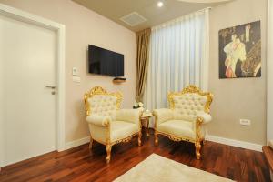 sala de estar con 2 sillas y TV en Silver & Gold Luxury Rooms, en Zadar